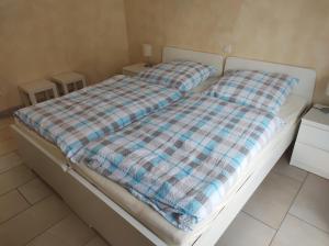 ein Bett mit einer karierten Decke in einem Schlafzimmer in der Unterkunft FeWo Holunderbusch in Saerbeck