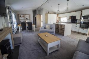 uma ampla sala de estar com uma cozinha e uma sala de estar em Stunning 4 Berth Lodge With Decking At Breydon Water In Norfolk Ref 10094b em Belton