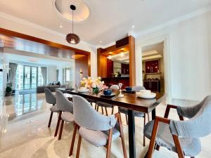 a dining room and living room with a table and chairs at 14 Pax Stylish Homestay 3 min walk to KLCC#10 min walk to Pavilion in Kuala Lumpur