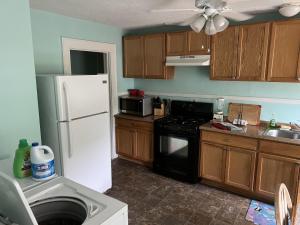 a kitchen with a white refrigerator and a stove at Historic Beach Side Getaway - Pet friendly, WiFi cottage in Norfolk
