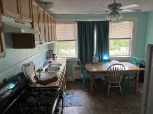 eine Küche mit einem Waschbecken und einem Tisch sowie ein Esszimmer in der Unterkunft Historic Beach Side Getaway - Pet friendly, WiFi cottage in Norfolk