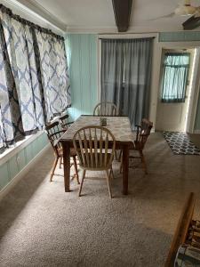 ein Esszimmer mit einem Holztisch und Stühlen in der Unterkunft Historic Beach Side Getaway - Pet friendly, WiFi cottage in Norfolk