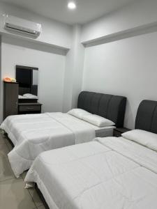 a room with two beds and a mirror at Manjung Vermogen Stay-Wi-Fi+KTV(Near Aeon) in Sitiawan
