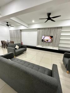 ein Wohnzimmer mit 2 Sofas und einem Flachbild-TV in der Unterkunft Manjung Vermogen Stay-Wi-Fi+KTV(Near Aeon) in Sitiawan