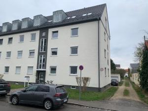 a car parked in front of a white building at Antoni Homes 2-4 Personen I 2 Schlafzimmer I Messe I Uni I Arena in Augsburg