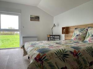 een slaapkamer met een bed met een kleurrijk dekbed en een raam bij L'échappée flamande in Hazebrouck