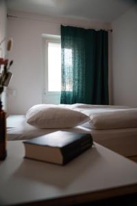 a book sitting on a table next to two beds at Bogentrakt in Chur