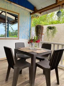 una mesa con sillas y un jarrón de flores en el patio en Villa Luz Ovelia, en El Valle
