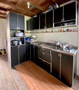 cocina con armarios negros, fregadero y fogones en Villa Luz Ovelia, en El Valle