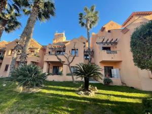 una gran casa con palmeras en el patio en Casa Estrellita - Lovely beachside 3 bedroom duplex flat, en Los Alcázares