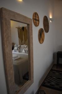 a mirror in a room with a bed and pillows at Infinity View Villas Mykonos in Kalo Livadi