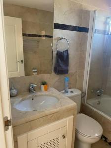 y baño con lavabo y aseo. en Casa Estrellita - Lovely beachside 3 bedroom duplex flat, en Los Alcázares