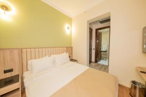 a bedroom with a large white bed and a mirror at Atik Palas Hotel in Istanbul