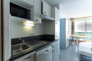 eine Küche mit einer Spüle und einer Mikrowelle in der Unterkunft Résidence Azureva Piau Engaly in Aragnouet
