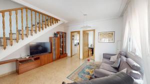 sala de estar con sofá y TV en Casa Margaritas-A Murcia Holiday Rentals Property, en San Pedro del Pinatar