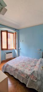 um quarto com uma cama com uma parede azul em Apartment Martina em Imperia