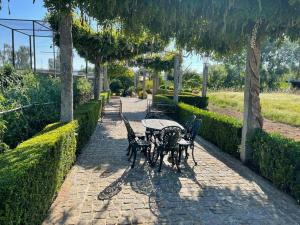 a table and chairs on a brick path with trees at Azenha São Rafael in Ribeirão