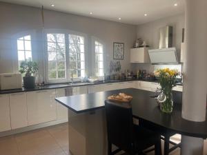 a kitchen with a table and a black counter top at DOMAINE DES PEYRIES - Chambres et table d'hôtes in Saint-Barthélémy-dʼAgenais
