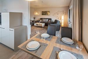 a kitchen and living room with a table and a refrigerator at Ferienhaus Neptun Norddeich in Norddeich