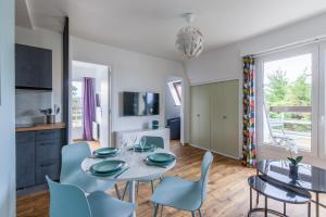 a kitchen and dining room with a table and chairs at Eole - Appt avec vue mer in Saint-Aubin-sur-Mer