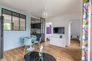 a kitchen and living room with a table and chairs at Eole - Appt avec vue mer in Saint-Aubin-sur-Mer