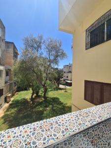 een uitzicht vanaf het balkon van een huis met een boom bij Dar Babou in Rabat