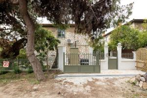 a gate in front of a house with a tree at Queen's stone legend, royal living by Acropolis in Athens