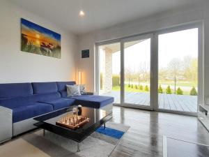 uma sala de estar com um sofá azul e uma mesa em Villa Aurea em Nowe Warpno