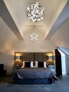 une chambre avec un grand lit et un lustre dans l'établissement Luxury holiday home sleeps 8-12 W/Hot Tub, à Worcester