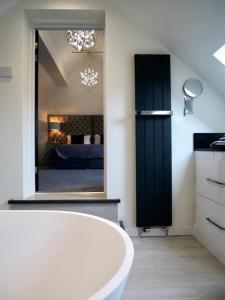 a bathroom with a white tub and a mirror at Luxury holiday home sleeps 8-12 W/Hot Tub in Worcester