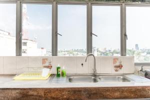 a kitchen counter with a sink and windows at Asian Residencies - Grandpass in New Bazaar