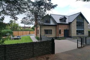 une maison avec une clôture devant dans l'établissement Luxury holiday home sleeps 8-12 W/Hot Tub, à Worcester