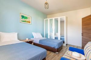 um quarto de hotel com duas camas e uma cadeira em Cosy, Sea View villa ''Andreas'' close to beach em Ligaria