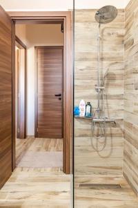 uma casa de banho com um chuveiro e uma parede de madeira em Cosy, Sea View villa ''Andreas'' close to beach em Ligaria