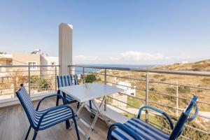 uma varanda com uma mesa e cadeiras e o oceano em Cosy, Sea View villa ''Andreas'' close to beach em Ligaria