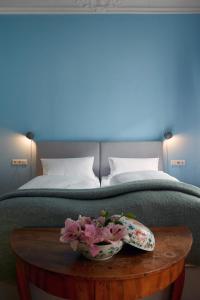 a bed with a table with a bowl of flowers on it at Wil7 Boutique Hotel in Berlin