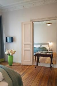 a bedroom with a bed and a table and a mirror at Wil7 Boutique Hotel in Berlin