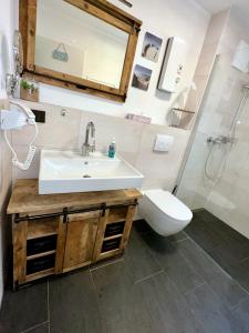 ein Badezimmer mit einem Waschbecken, einem WC und einem Spiegel in der Unterkunft Küstenliebe Graal-Müritz in Gelbensande