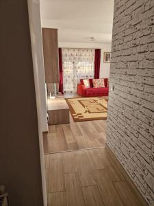 uma sala de estar com um sofá vermelho e uma parede de tijolos em Casă și curte confortabilă em Brasov
