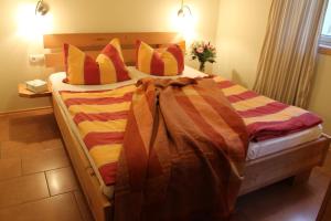 um quarto com uma cama grande com lençóis e almofadas coloridos em Ferienhaus Norway em Wittenbeck