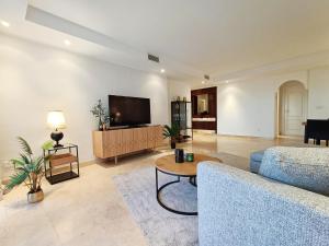 a living room with a couch and a tv at Oasis 3 bedroom Marbella Golden Mile in Marbella