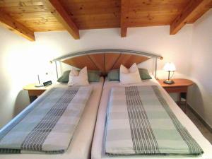 2 Einzelbetten in einem Schlafzimmer mit Holzdecke in der Unterkunft Ferienwohnung Sunkler in Waging am See