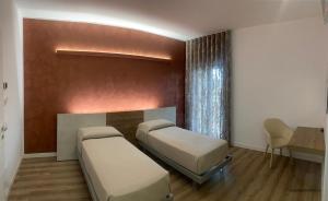 um quarto de hospital com duas camas e uma mesa em LD Ianuzziello Residence em Scanzano Jonico