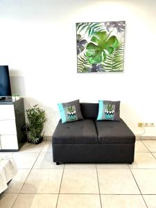 un sofá negro sentado en una sala de estar en Studio de standing au Gosier en Le Gosier