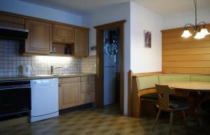 una cocina con armarios de madera, mesa y fregadero en Sonnkogl, en Wildschönau