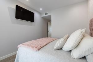 a bedroom with a bed with a flat screen tv on the wall at Los Alamos Beach Flat in Torremolinos