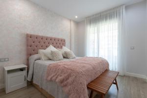 Un dormitorio con una cama rosa con una manta rosa y una ventana en Los Alamos Beach Flat, en Torremolinos