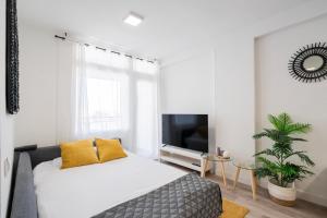 um quarto branco com uma cama e uma televisão em For you Rentals Moderno apartamento cerca ZOO y del Parque de Atracciones CEB76 em Madri