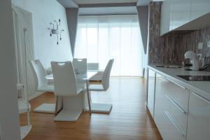 - une cuisine blanche avec des chaises blanches et une table dans l'établissement 爪ㄚ ㄥㄖ千ㄒ, à Florence