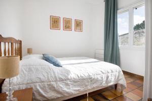 a white bedroom with a bed and a window at Villa PIERROT avec grand jardin arboré, proche du port et des restaurants in La Flotte +5 photos